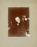 Im Jahr 1905: Thomas Edison mit einem Glaskolben, in dem ein Leuchtfaden Licht gibt.