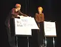 Diese beiden stummen Künstler sprechen mit großen Postern.