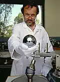 Der Wissenschaftler zeigt einen kugelrunden Kristall aus Silizium, der genau ein Kilogramm schwer sein soll.