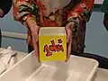 Diese Dame hält ein Gefäß hoch, in das genau ein Liter Wasser passt.