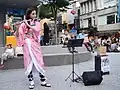 Eine Flötistin spielt hier in Japan ein Straßenkonzert.