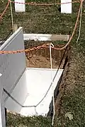 Ein noch offenes Grab auf einem Friedhof. Hier kommt ein Sarg hinein.