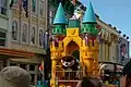 Eine Parade in einem Disneyland-Park mit Figuren, die von Menschen bewegt werden.