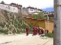 Mönche vor dem Kloster Ganden. Es wurde im Jahr 1966 von chinesischen Kommunisten zerstört und später wieder neu gebaut.