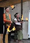 Auf einem Mittelalter-Festival: Zwei Jongleure mit brennenden Fackeln.