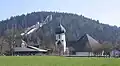 Die Kirche in Hinterzarten. Im Hintergrund sieht man eine Skisprungschanze
