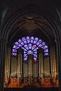 Die Orgel wurde beim Brand im April 2019 beschädigt. Dahinter das gotische Rosettenfenster in den für die Gotik typischen Farben Blau-Rot.