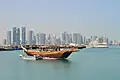 Ein Boot vor den Hochhäusern von Doha
