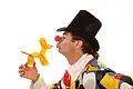 Clown mit einem Hund, den er aus einem langen Luftballon gedreht hat