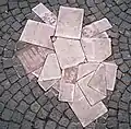 Diese „Flugblätter“ sind aus Marmor. Sie wurden 1988 vor der Uni München in das Pflaster eingelassen. Damit soll an die Aktionen der Weißen Rose erinnert werden.