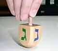 Auf diesem jüdischen Kreisel stehen vier Buchstaben des hebräischen Alphabets. Hier sind es das G und das N.