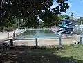Ein Freibad mit Schwimmbecken sowie einer mittleren und einer langen Rutsche