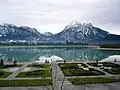 Ein Blick über den Forggensee: In der Mitte im Gebirge sieht man klein das Schloss.