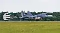 Ein Flugzeug landet: Der Fallschirm bremst das Flugzeug ab, damit es keine so lange Landebahn braucht.