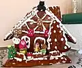 Ein Lebkuchenhaus aus Österreich mit Marzipanfiguren: Hänsel, Gretel und die böse Hexe.