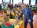 Diese Kinder sind bereit für ein Dame-Turnier. Der Bürgermeister der Stadt eröffnet es.