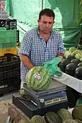 Hier wird eine Melone abgewogen, die nach ihrem Gewicht bezahlt wird.