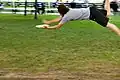 Dieser Mann fängt eine Frisbee-Scheibe.