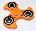 Diese beliebten Spielzeugkreisel nennt man Fidget Spinner. Man sagt „fidschet spinner“.