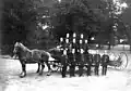 Um das Jahr 1900 in Uetersen, Schleswig-Holstein: Feuerwehrleute mit Pferd und Wagen.