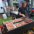 Eine Bratwurst-Verkäuferin auf einem Jahrmarkt in Polen
