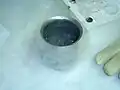 Ein Gefäß mit flüssigem Stickstoff. Er ist extrem kalt und verdampft schon bei Zimmertemperatur.
