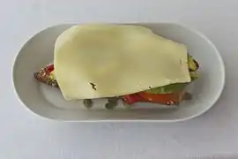 Mit einer Käsescheibe belegt, bereit zum Überbacken
