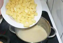 Suppe und Schlagsahne vermengen, aufkochen lassen und die Kartoffelstücke darin weich kochen.