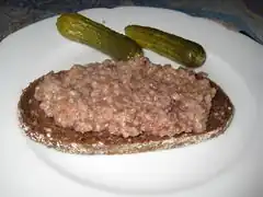 Knipp; gebraten, auf Schwarzbrot mit saurer Gurke