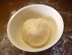 Den Teig nach dem Gehen gut verkneten und schließlich daraus gleichmäßige Bällchen formen.