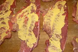die Rouladen mit Senf einstreichen