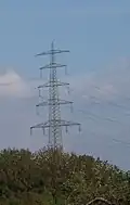 Tannenbaummast einer Hybridleitung mit vier Ebenen und zwei Blitzschutzseilen; die unterste Ebene ist eine Bahnstromleitung von DB Energie