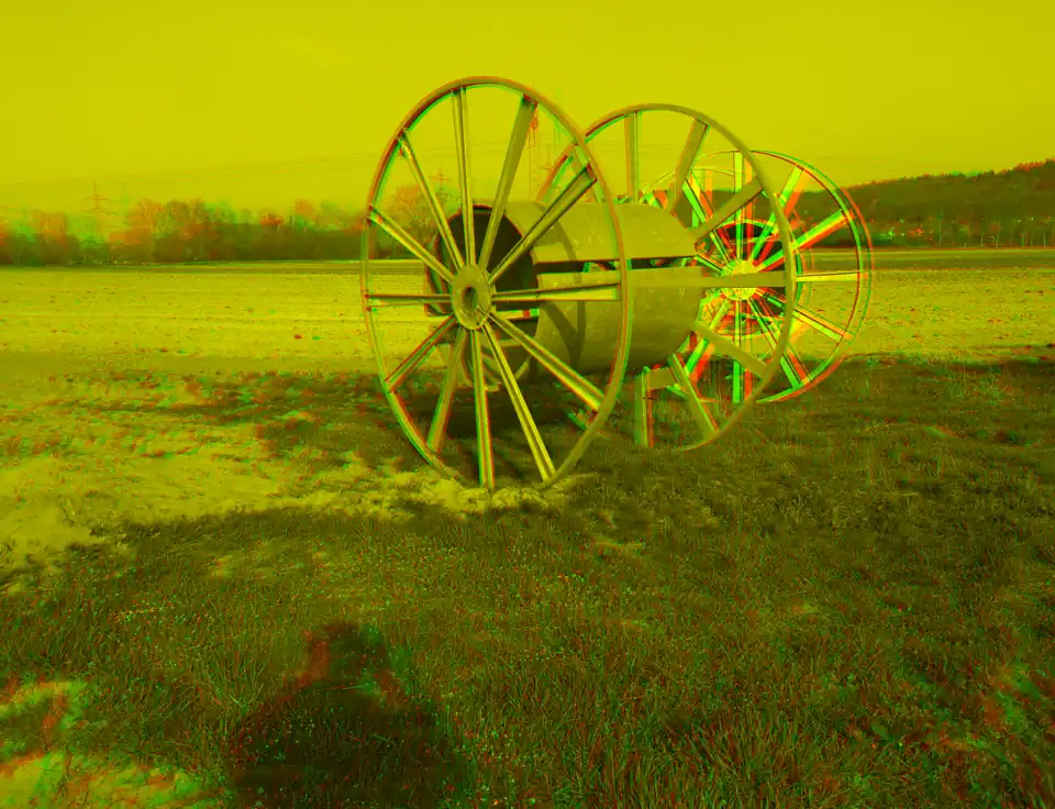 Anaglyph-3D-Bild von zwei Kabelrollen auf einem Feld. Verwenden Sie zur Ansicht den Grünfilter vor dem linken Auge und den Rotfilter vor dem rechten Auge
