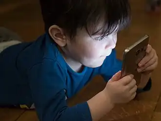 A child looks into a smartphone